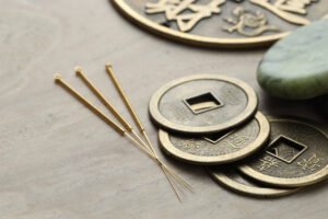 Acupuncture needles and ancient coins on table