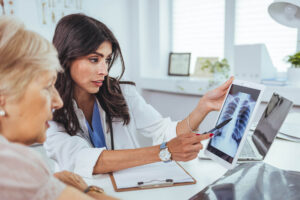 Doctor shows results to senior patient x-ray of the lungs